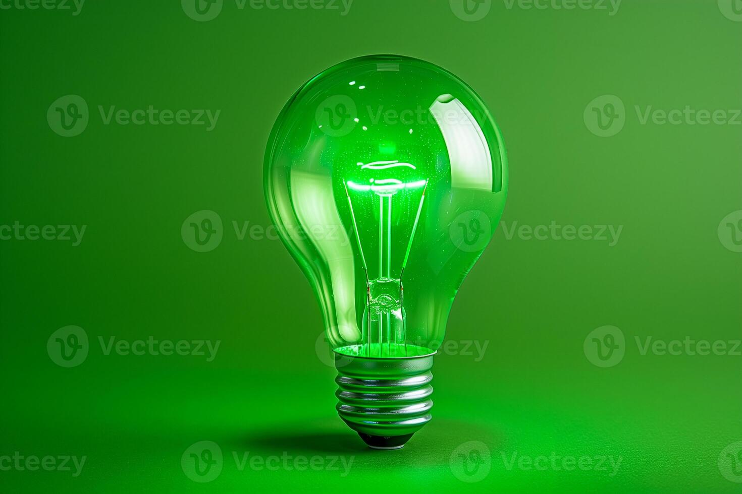 Llight bulb glowing with light on green background, copy space photo