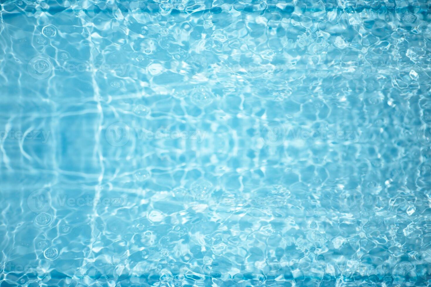 Blue water with ripples on the surface. Defocus blurred transparent blue colored clear calm water surface texture with splashes and bubbles. Water waves with shining pattern texture background. photo