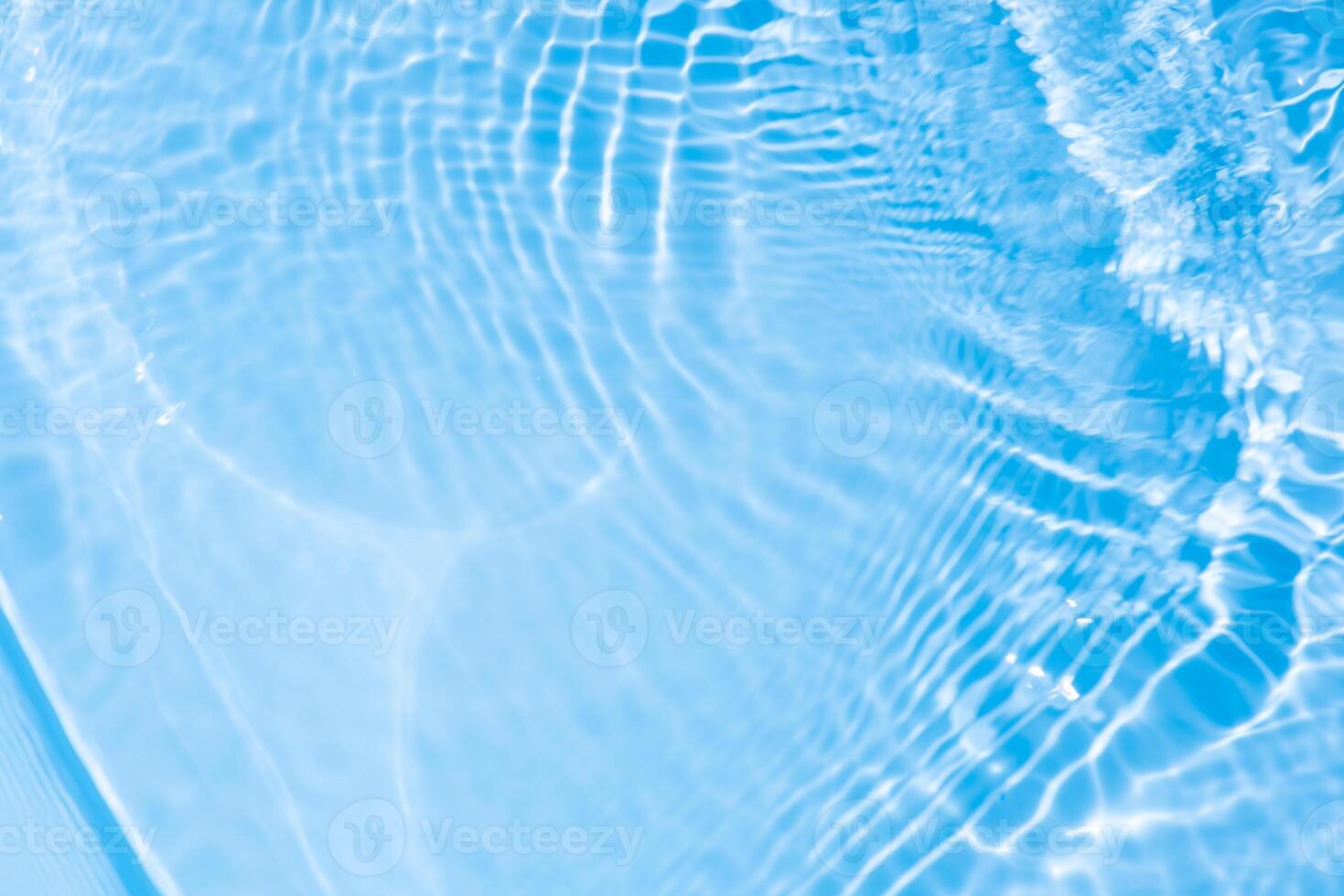 Bluewater waves on the surface ripples blurred. Defocus blurred transparent blue colored clear calm water surface texture with splash and bubbles. Water waves with shining pattern texture background. photo