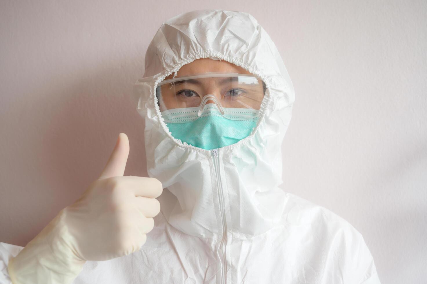 Nurse wearing PPE suit with mask for protect virus and showing thumbs up. photo