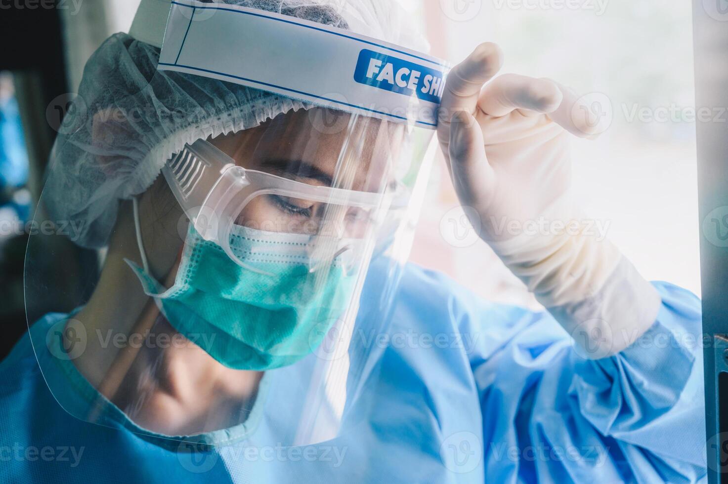 Nurse having headache and tired from work while wearing PPE suit for protect coronavirus disease. photo