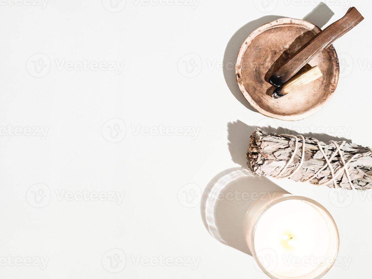 Items for spiritual cleansing - sage bundle, palo santo incense sticks and candle on white background. photo