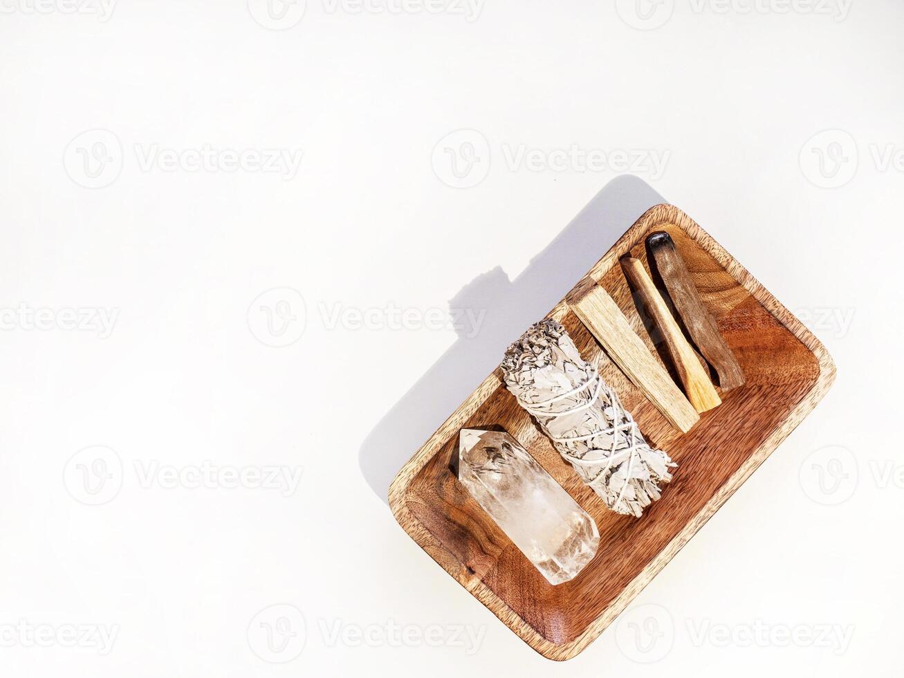 Items for spiritual cleansing - sage bundle, palo santo incense sticks and quartz crystal photo