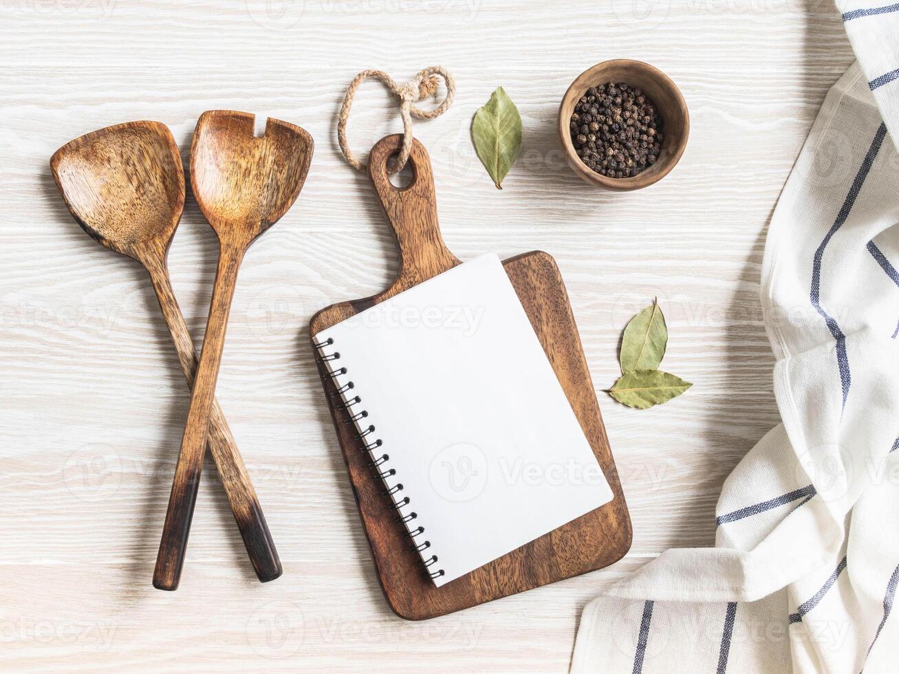 Minimal white kitchen background with blank notebook for text, cutting board, cotton napkin and various spices photo