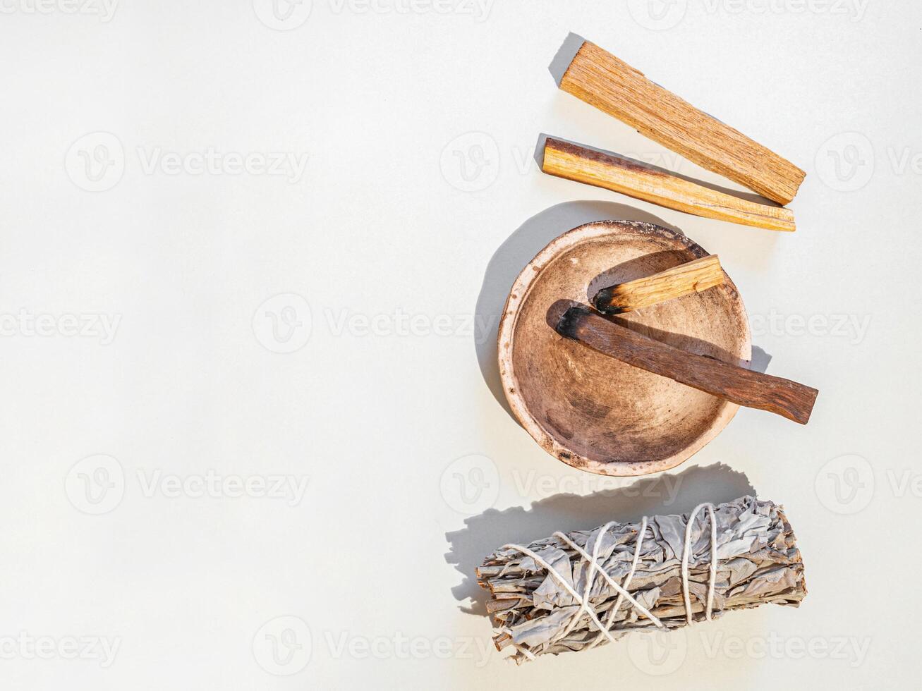 Items for spiritual cleansing - sage bundle, palo santo incense sticks on white background. photo