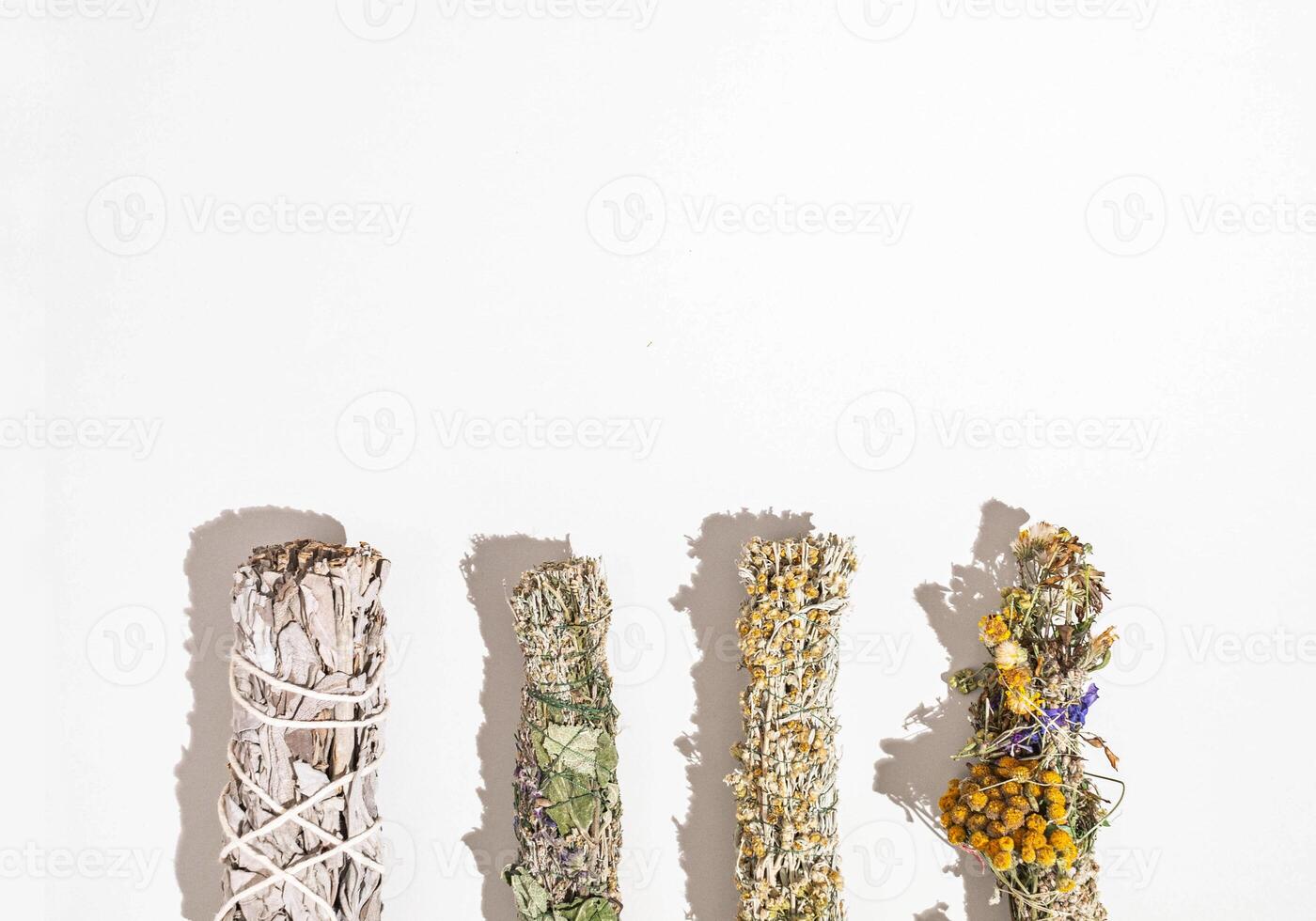 Herbs for spiritual cleansing - white sage and various aromatic herbs bundles on white background photo