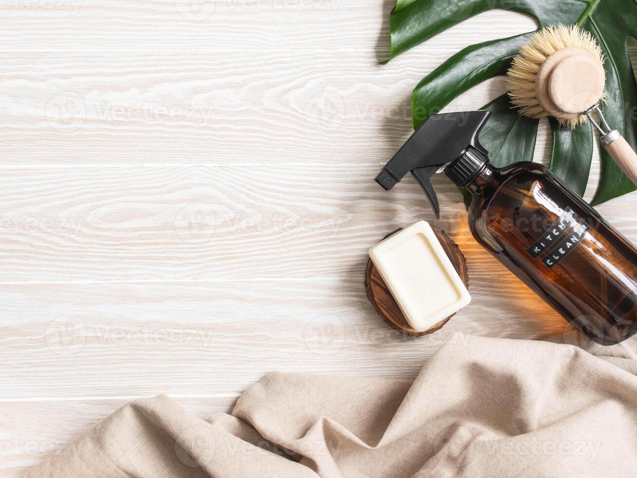 Amber bottle with washing solution, brush and soap on white wood table. photo