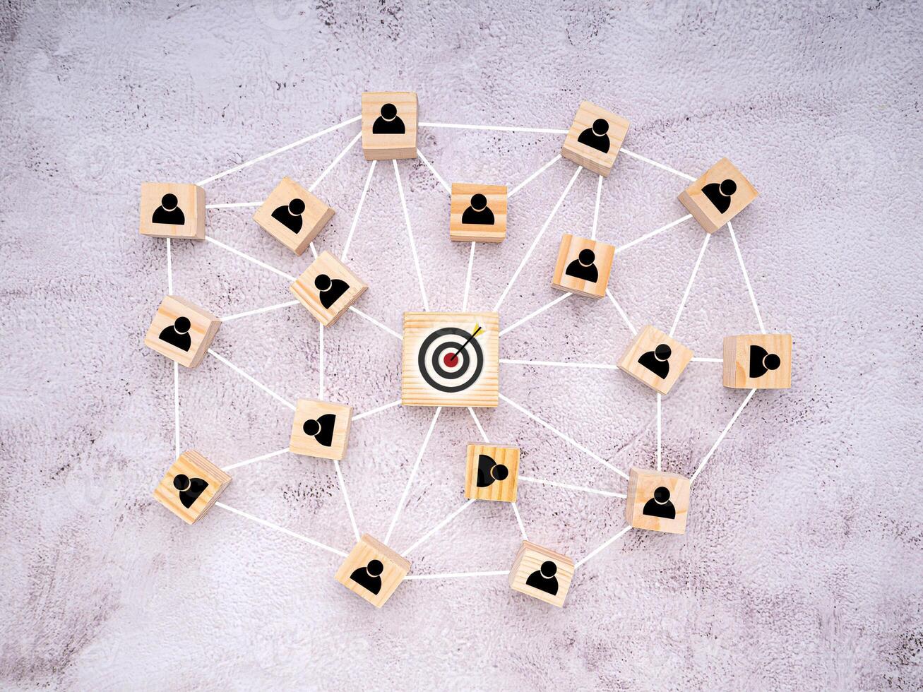 Focus on goal business. Network, teamwork, and unity concept. Top view of wooden blocks with human and goal icons on cement background, Flat lay, space for text photo