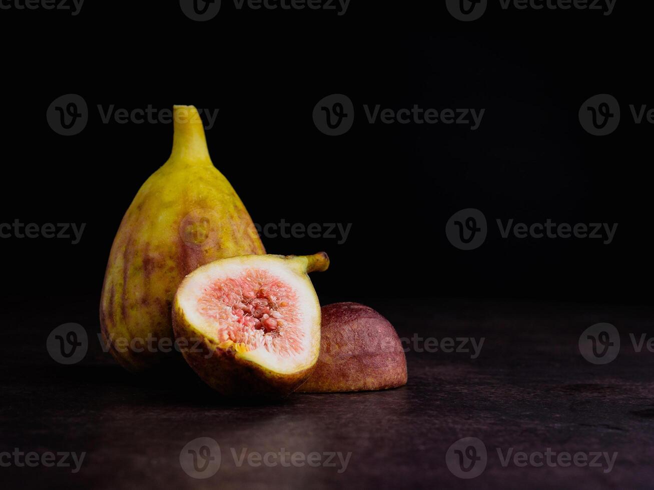 Ripe figs fruit are on vintage background with a black wall. High Vitamins fruit. Space for text. Healthy fruits and healthcare concept photo