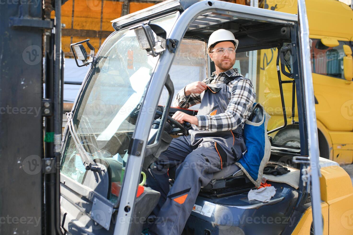 A man on a forklift works in a large warehouse, unloads bags of raw materials photo