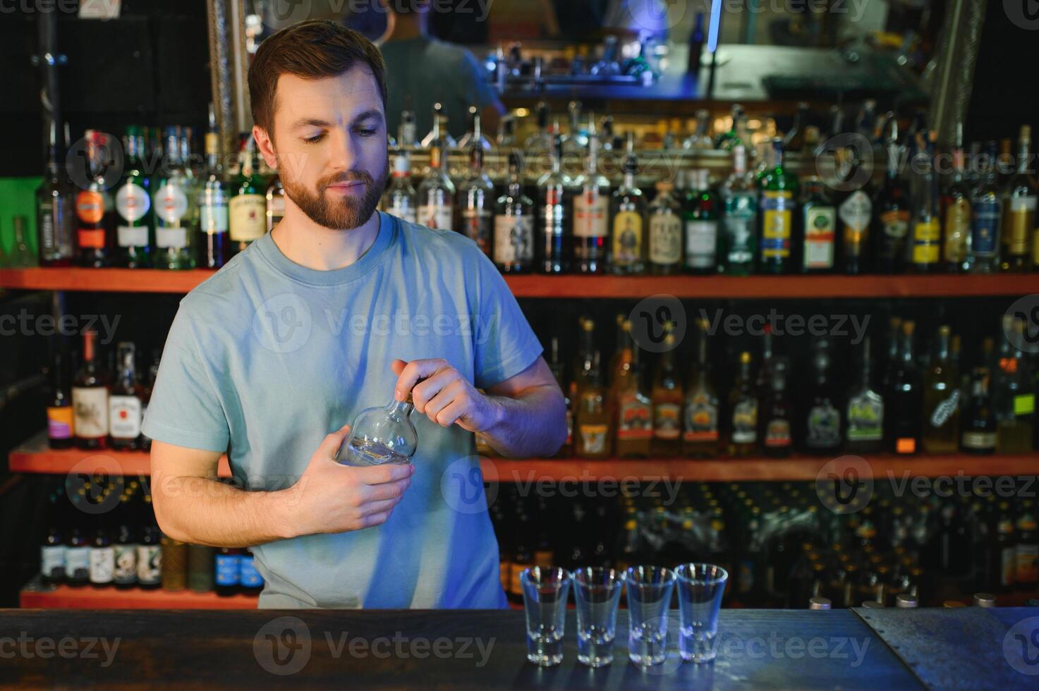 Handsome bar tender standing behind his counter in a pub photo