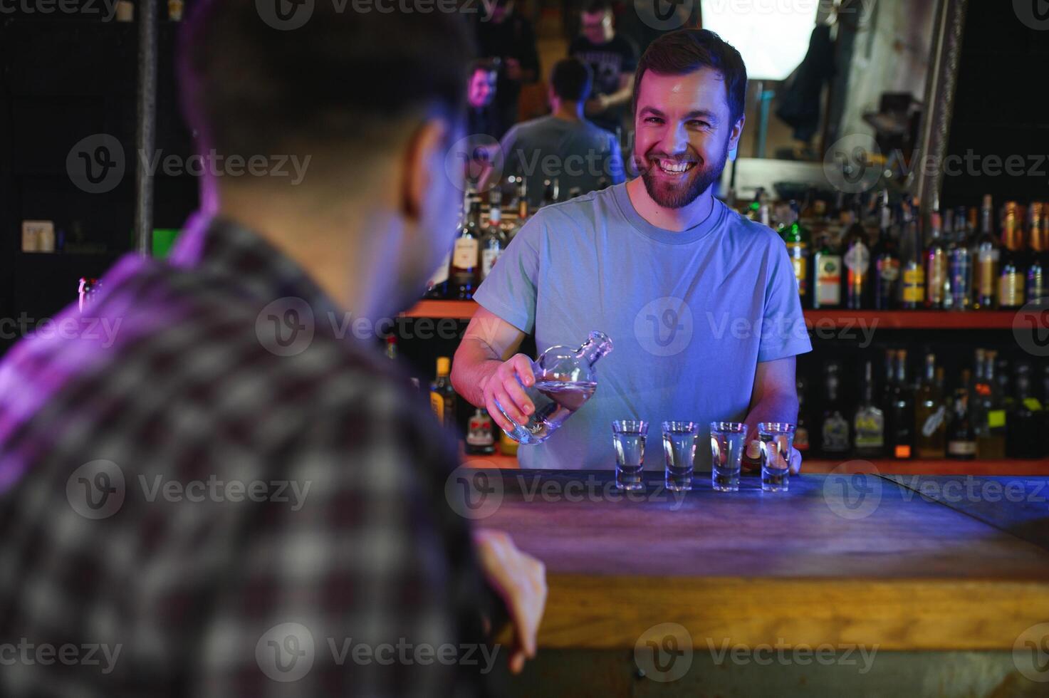 Handsome bar tender standing behind his counter in a pub photo