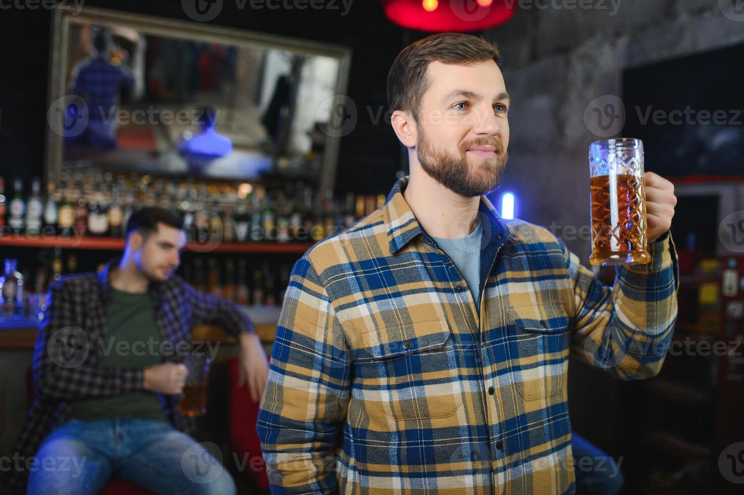 Night in bar. Portrait of cheerful men drinking beer at the bar photo