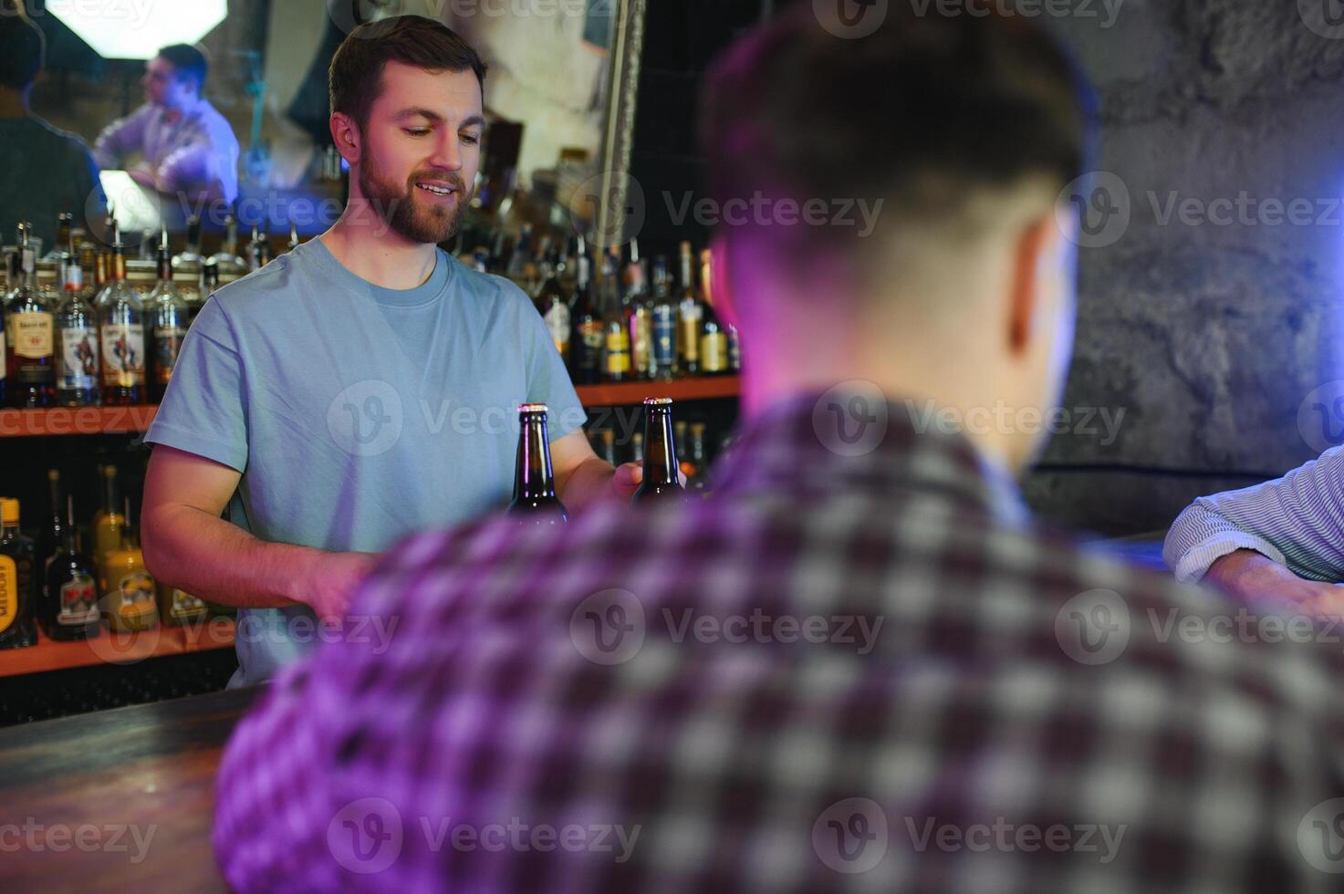 Handsome bar tender standing behind his counter in a pub photo