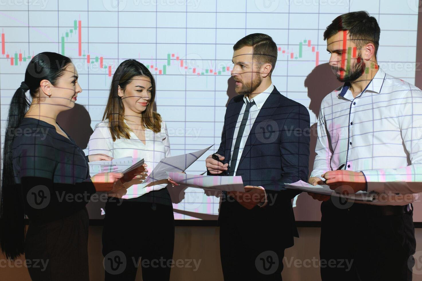 Group of business people working at modern office.Technical price graph, red and blue candlestick chart and stock trading computer screen background. Double exposure. Traders analyzing data photo