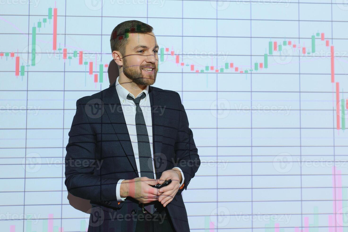 Man is standing near projector and showing graphs and business graphs. photo