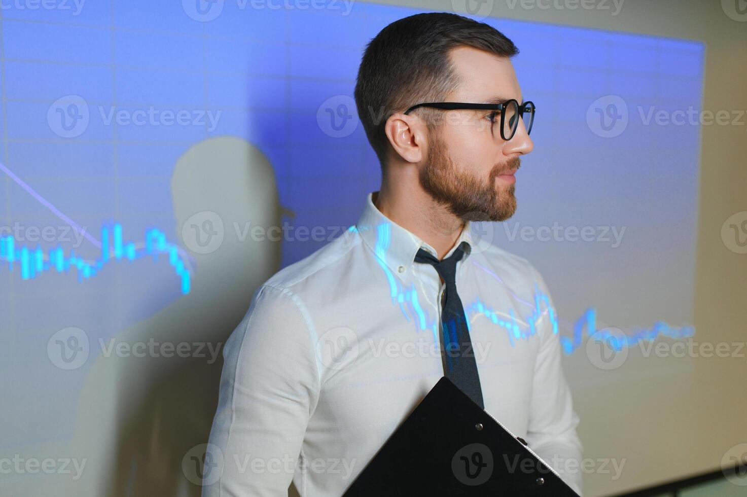 Portrait of concerned European businessman thinking in blurry office with double exposure of falling financial chart. Concept of crisis and stock market. photo