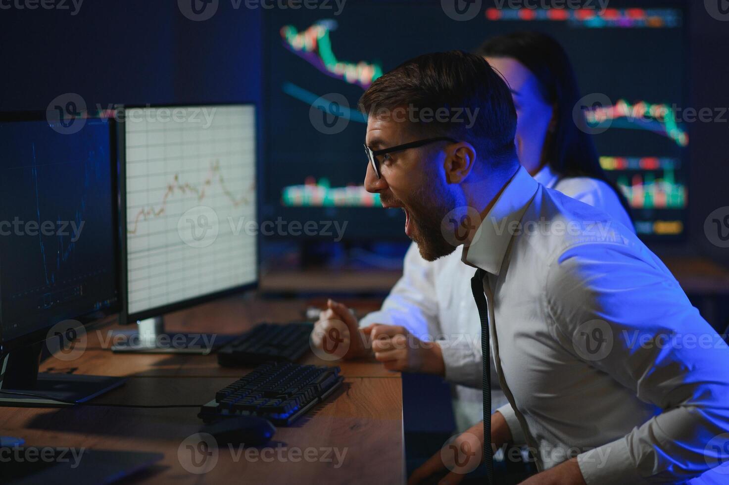 Team of stockbrokers are having a conversation in a dark office with display screens photo