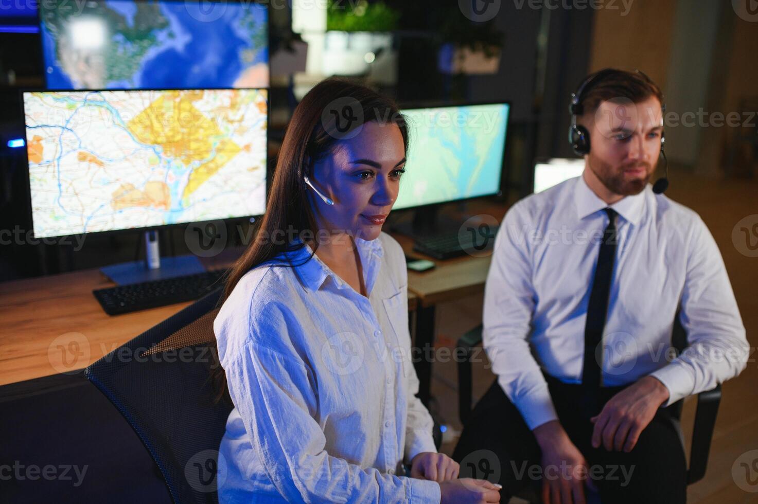 Center of dispatching maintenance. Portrait of cheerful woman and man working via headset microphone while sitting on navigation controller board photo
