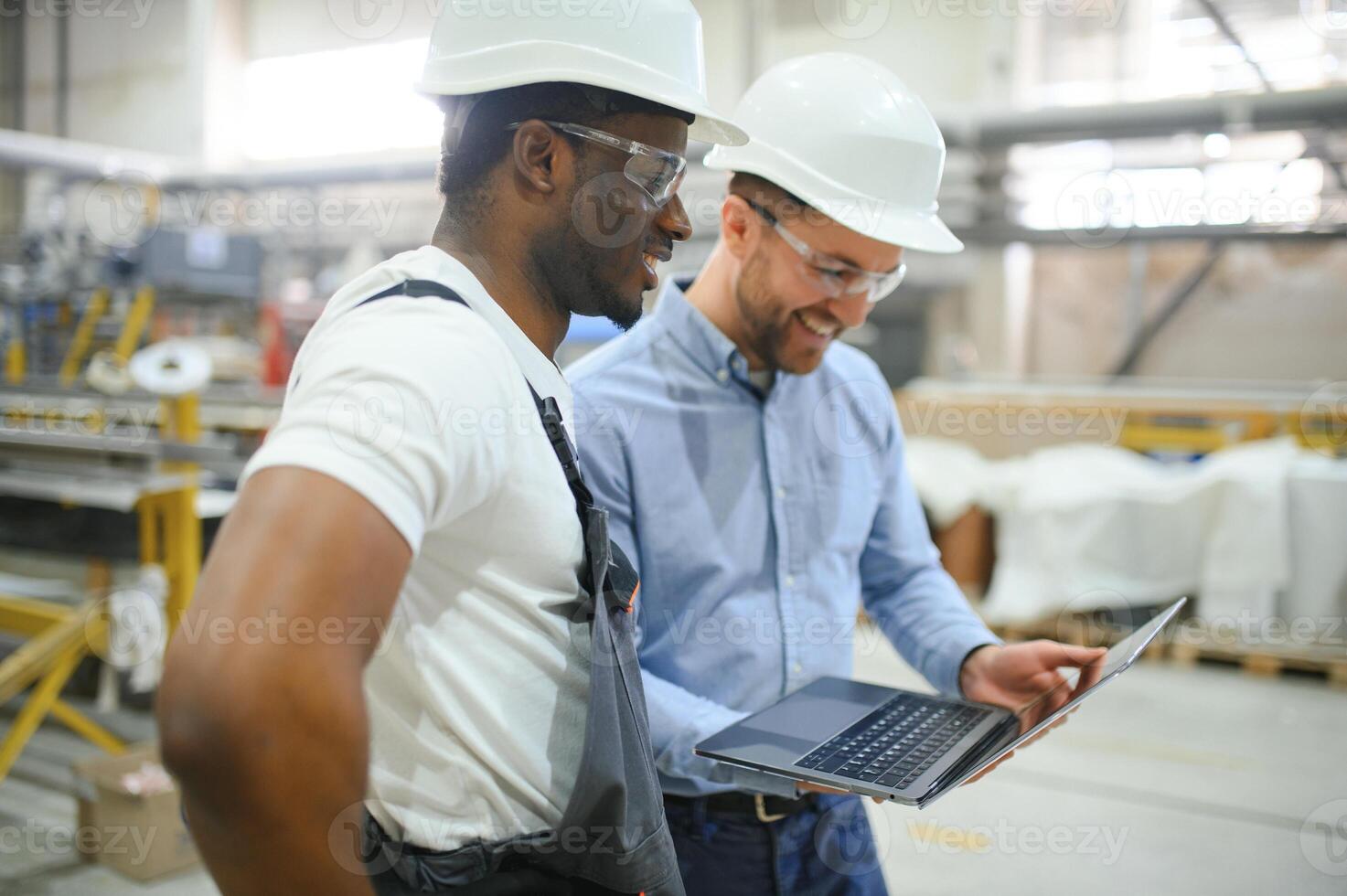 Two workers at a factory for the production of plastic windows. Engineer and worker on the production line photo