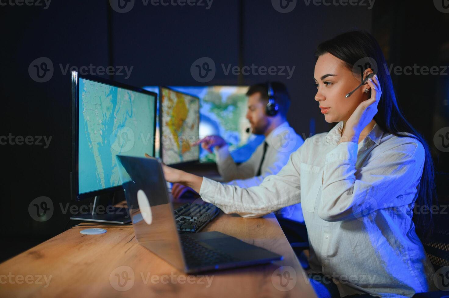 Center of dispatching maintenance. Portrait of cheerful woman and man working via headset microphone while sitting on navigation controller board photo