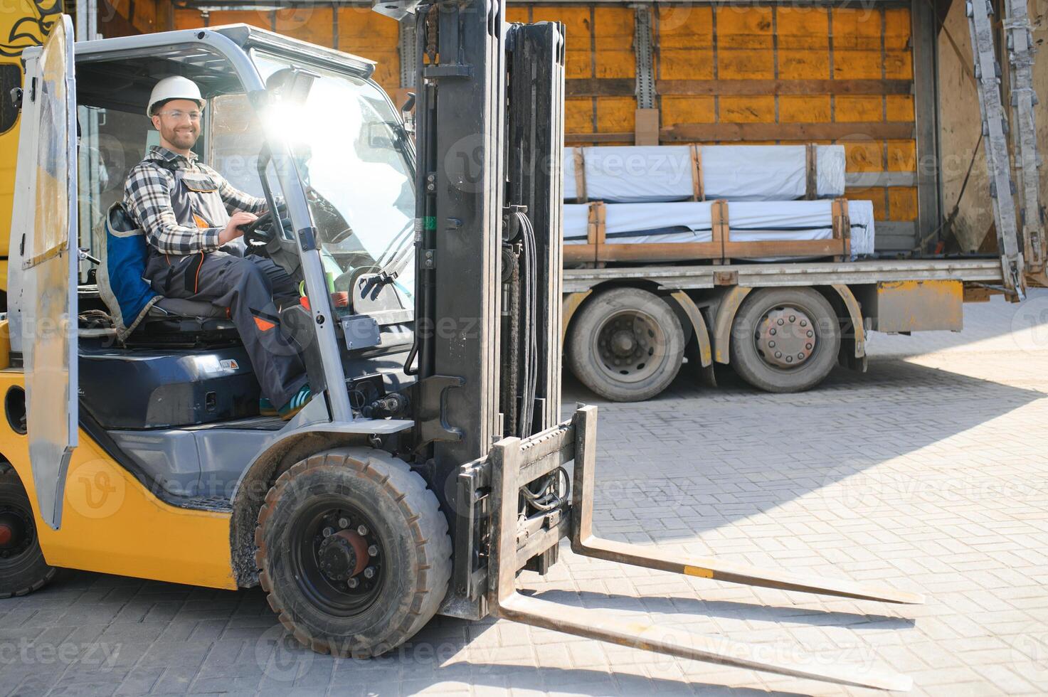 A man on a forklift works in a large warehouse, unloads bags of raw materials photo