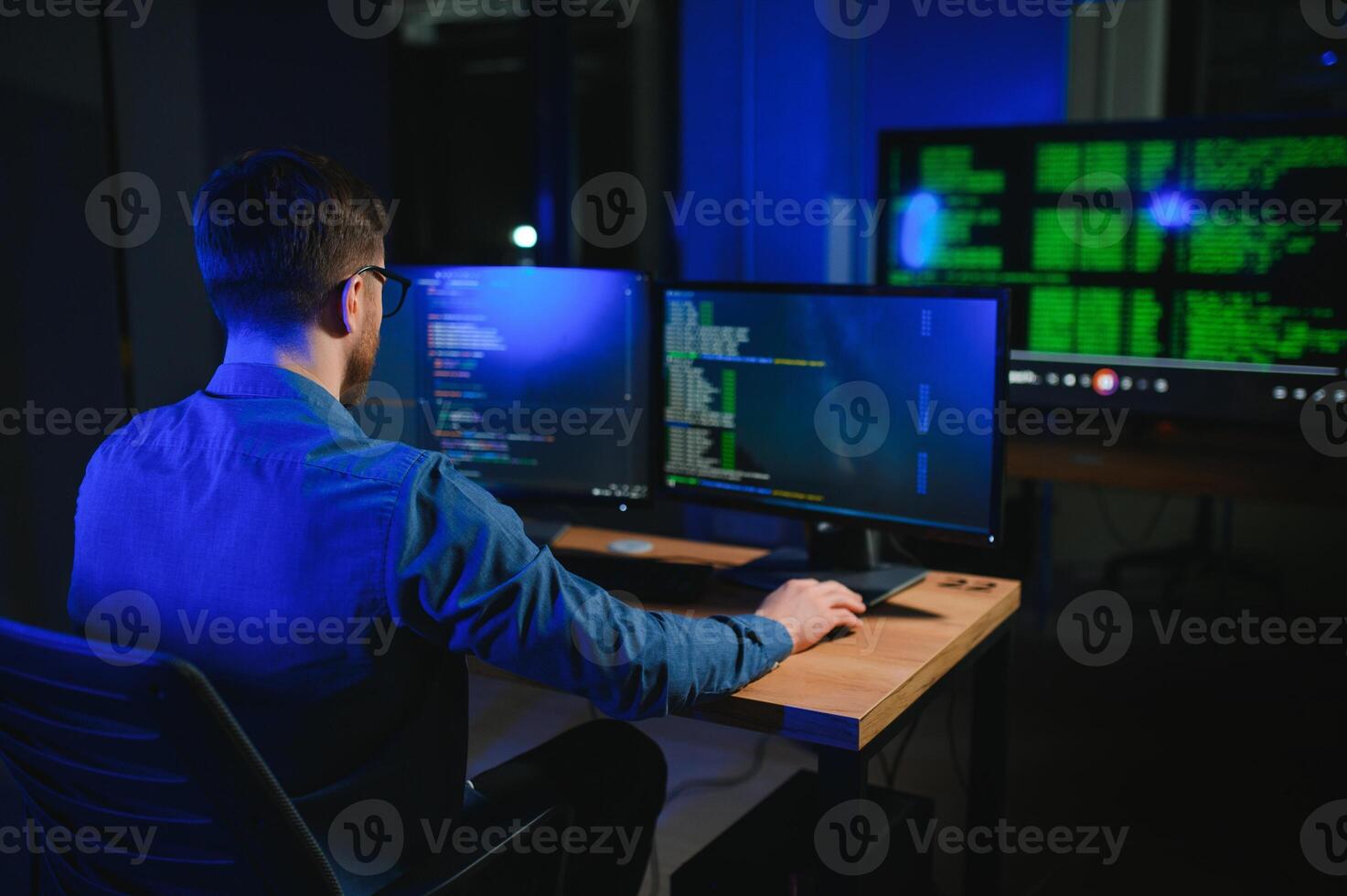 Male programmer working on desktop computer at white desk in office photo