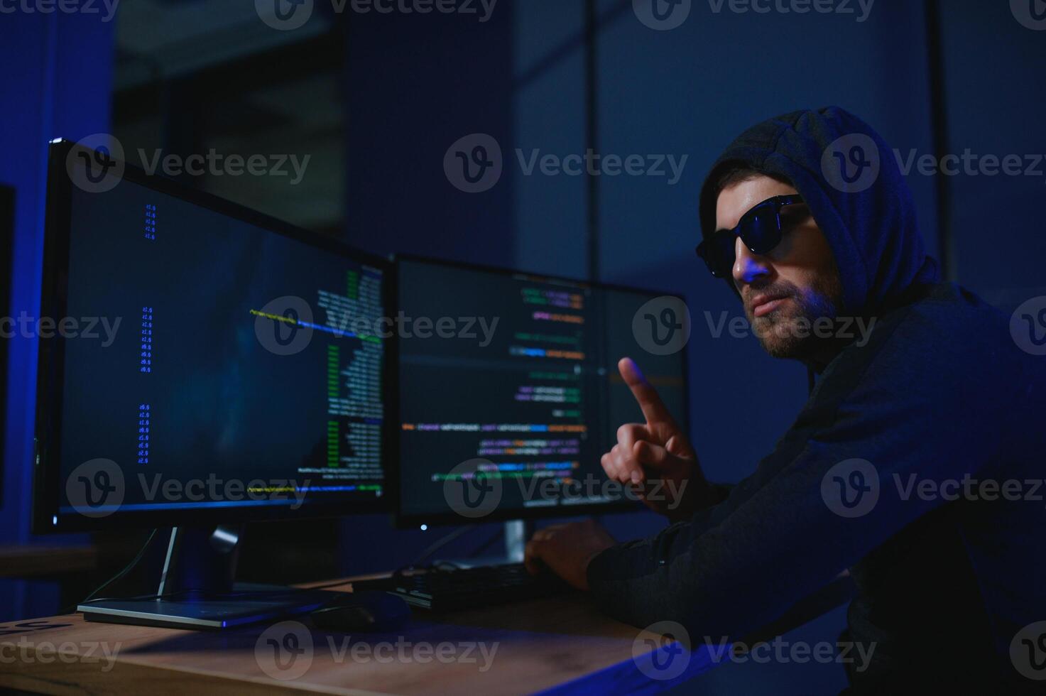 hacker sentado a escritorio en oscuro atmósfera. un computadora programador o hacker anónimo computadora hacker foto