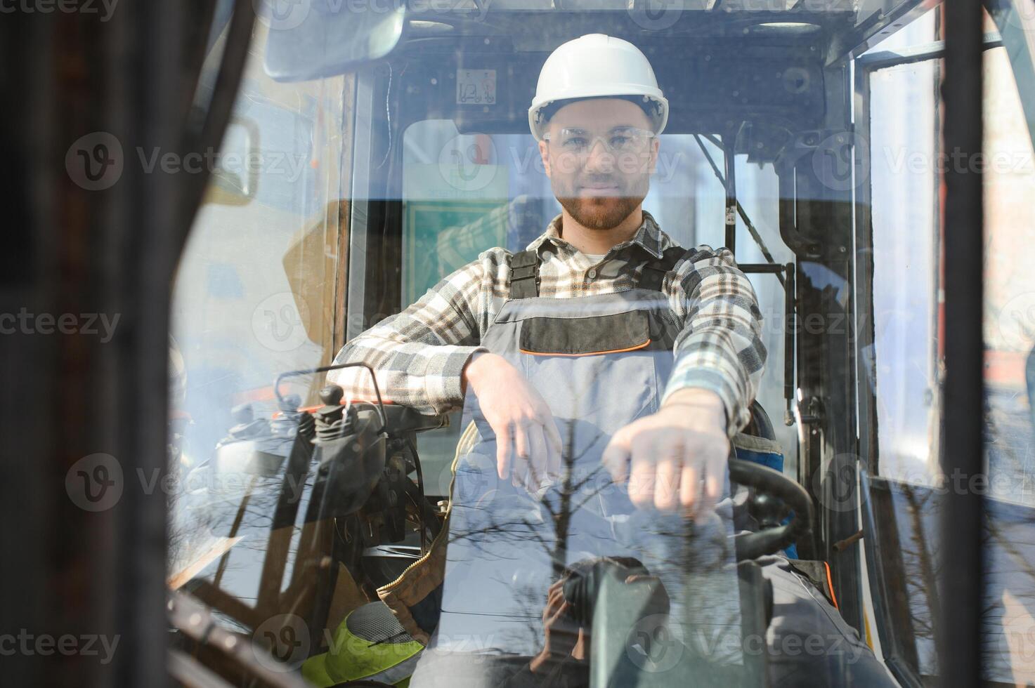 Portrait of heavy industry forklift driver giving thumbs up and smiling photo