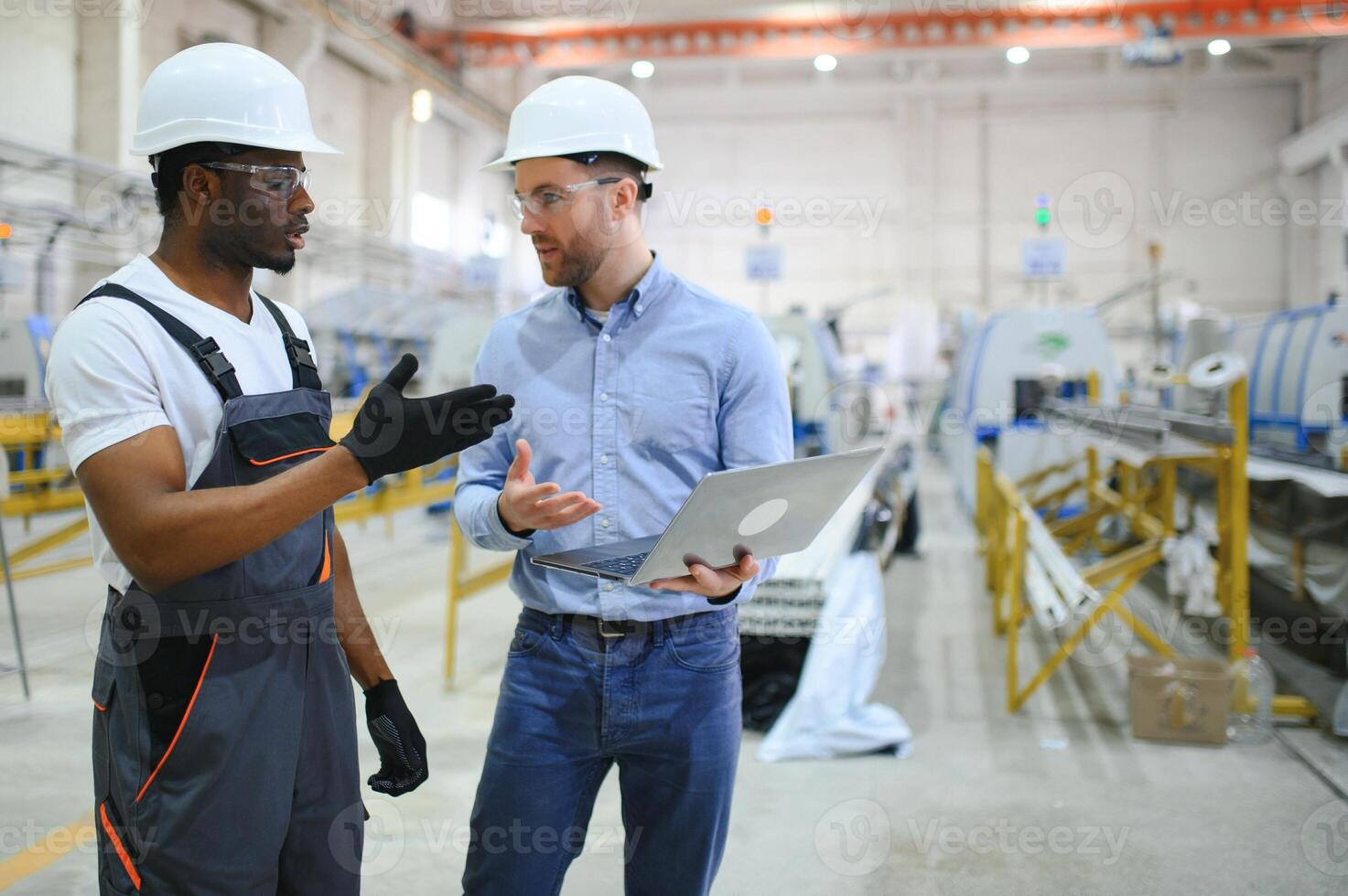 Two workers at a factory for the production of plastic windows. Engineer and worker on the production line photo