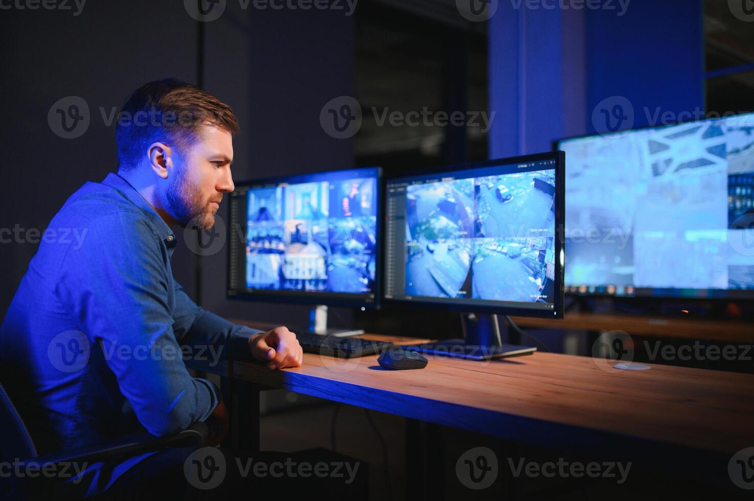 Security operator controls CCTV cameras in office at night. Modern security system and social safety concept photo