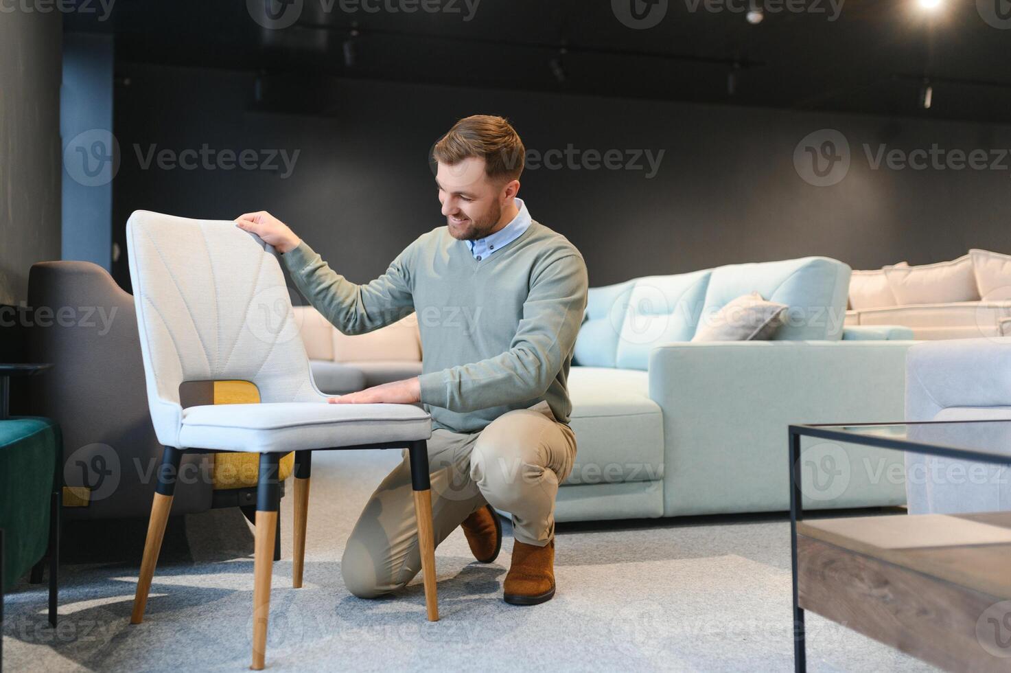 Front view of customer choosing chair in furniture store. photo