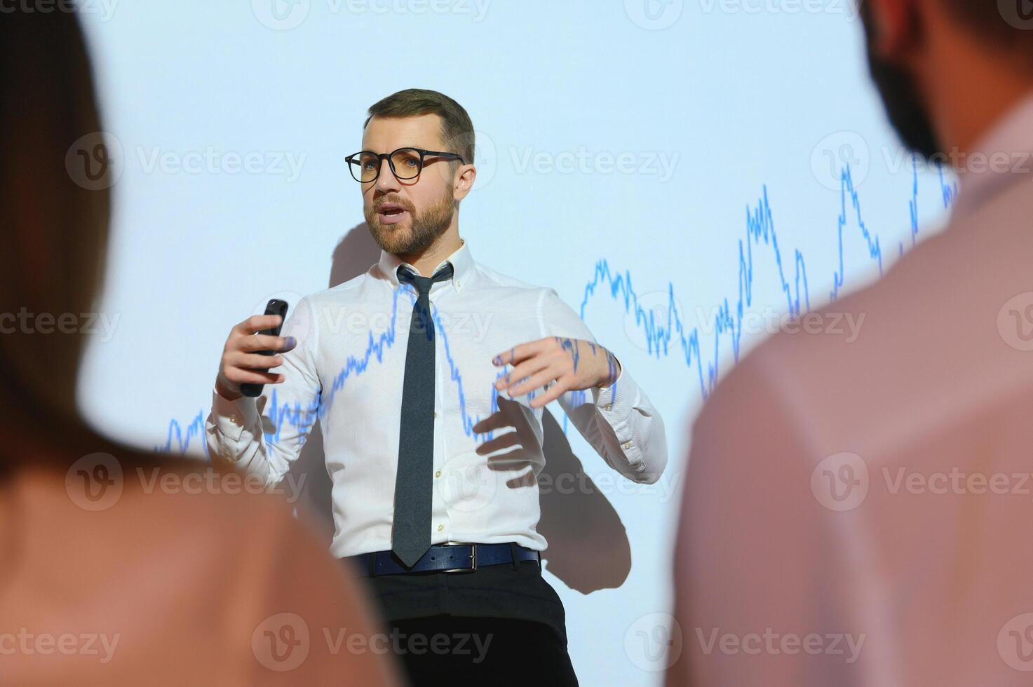 Businessman does Financial Analysis talks to Group of Businessspeople. Projector Screen Shows Stock Market Data, Investment Strategy, Revenue Growth photo
