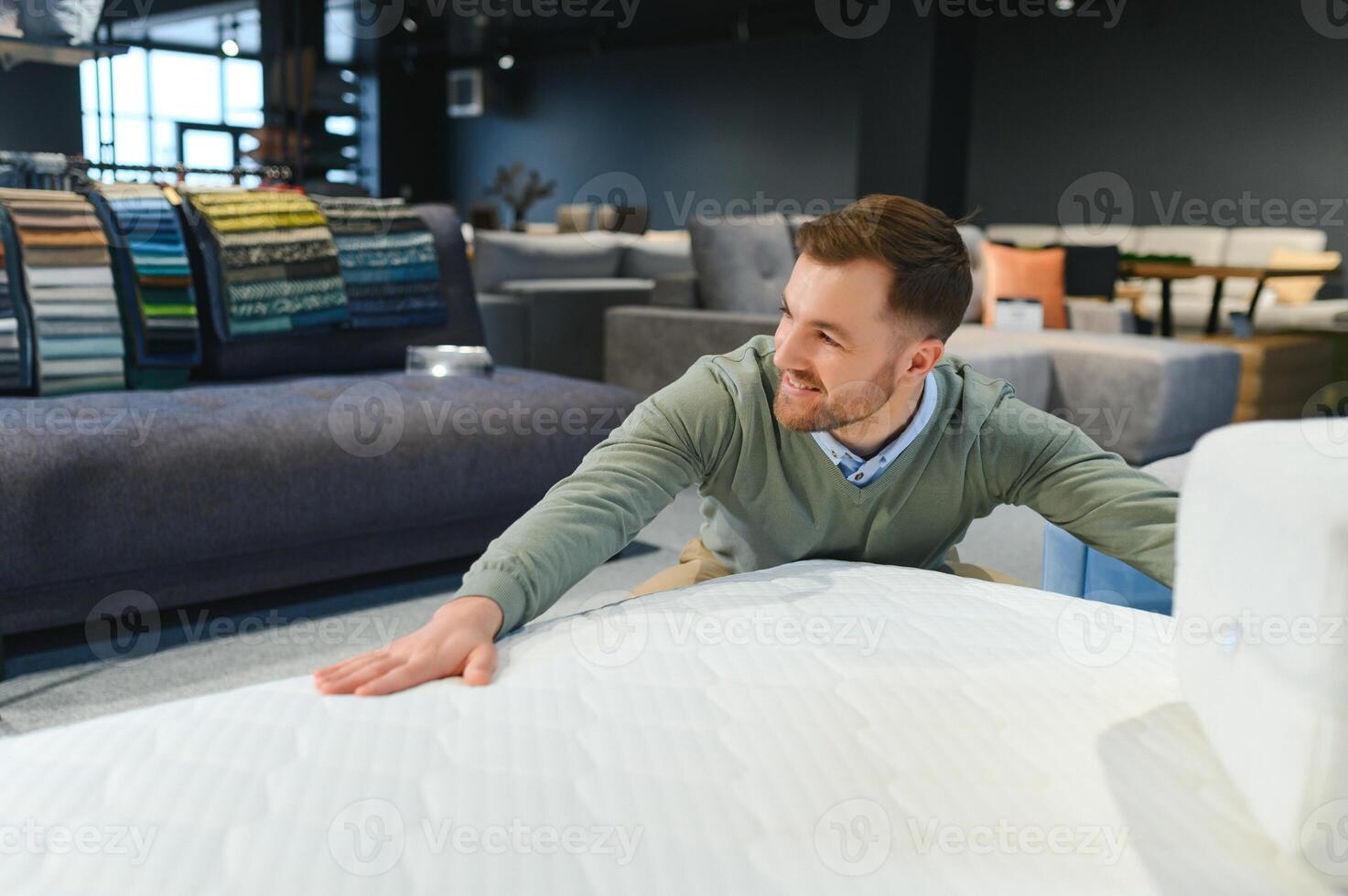 Man choosing orthopedic mattress in store photo