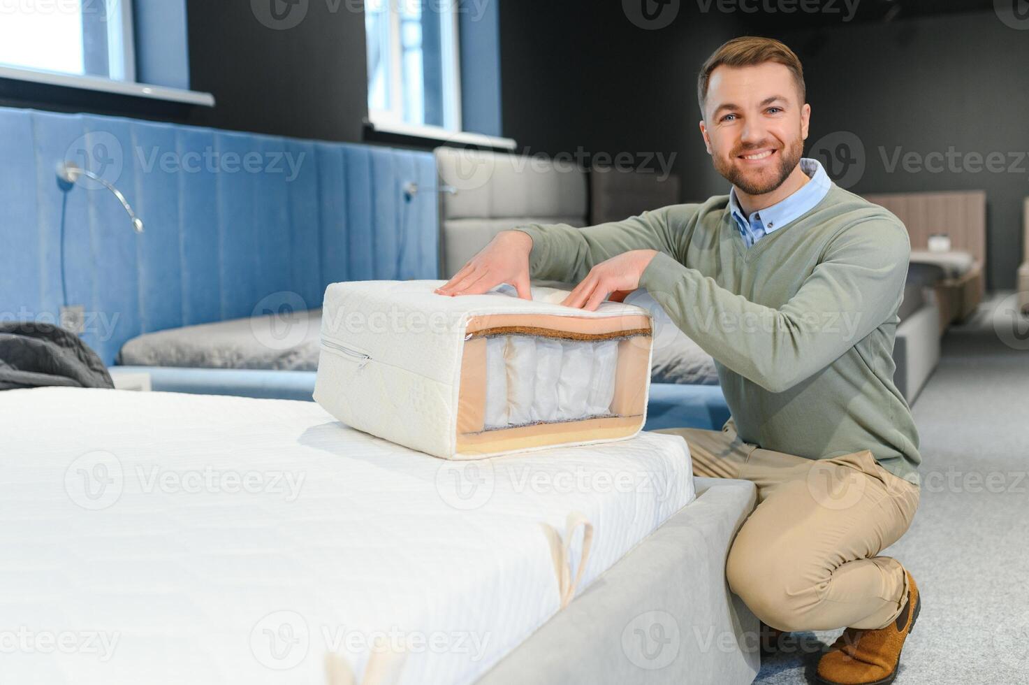 Man choosing orthopedic mattress in store photo
