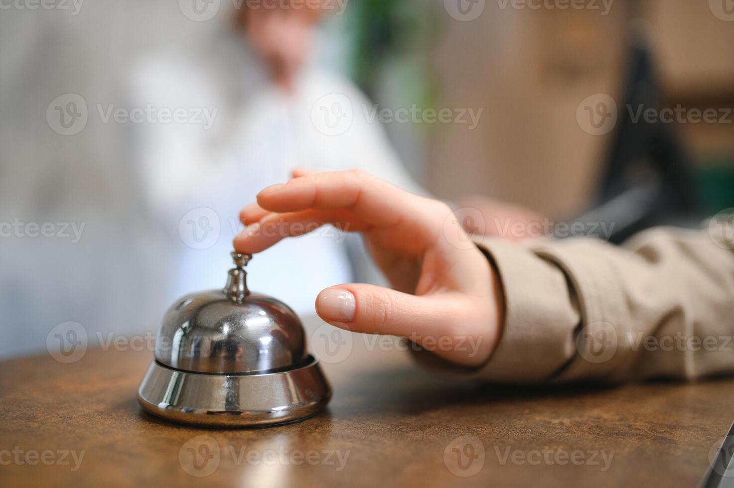Hand of a woman using a hotel bell photo