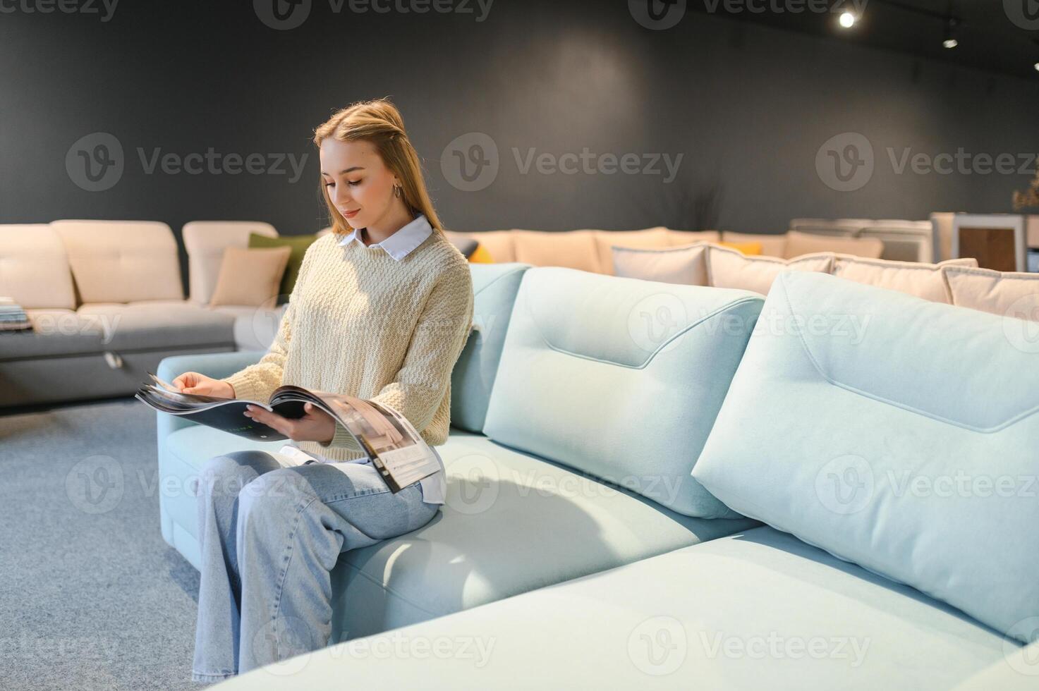Woman designer at furniture store looking at textile swatch photo