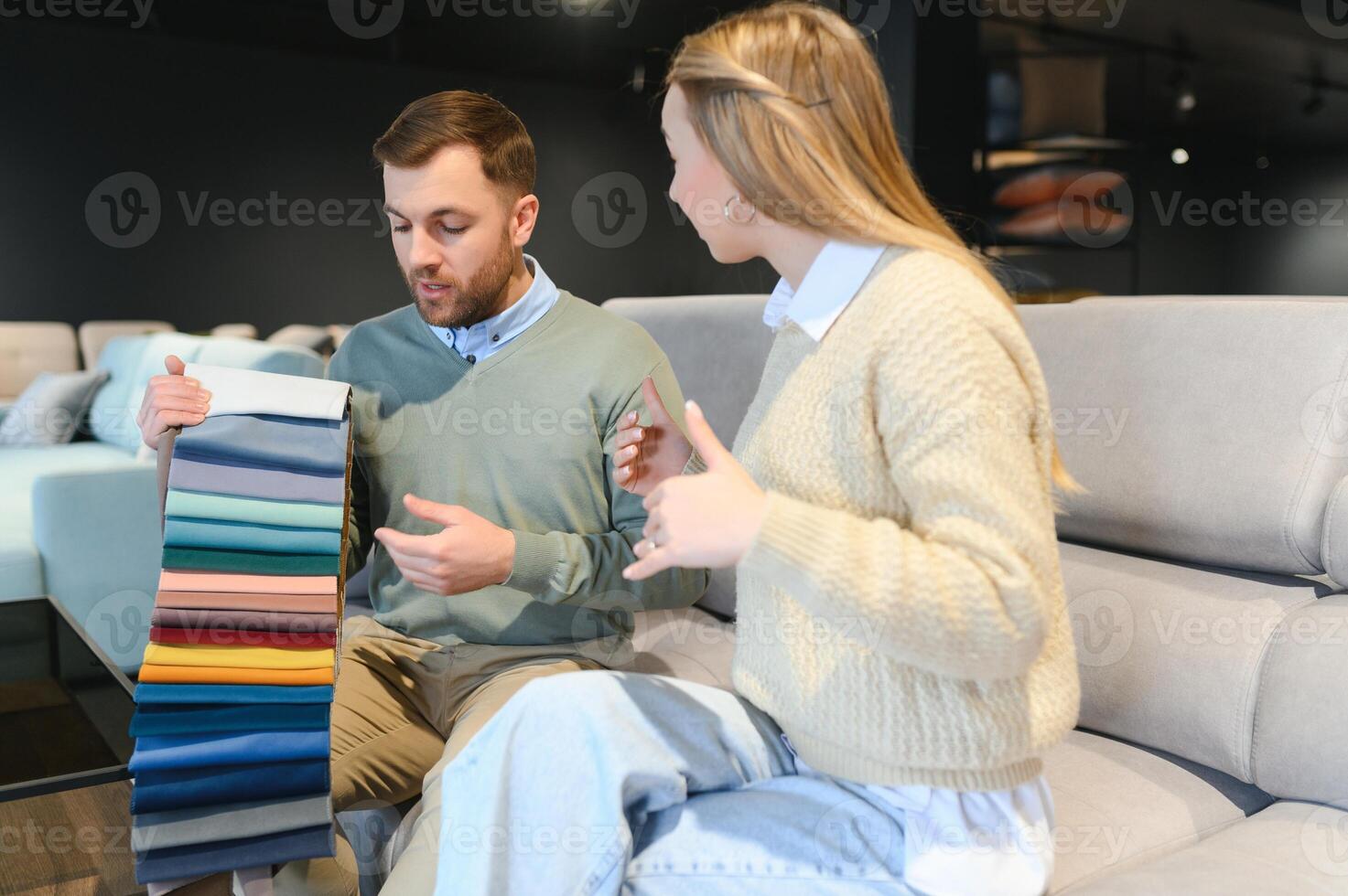 Woman and man looking at textile swatch in furniture store photo