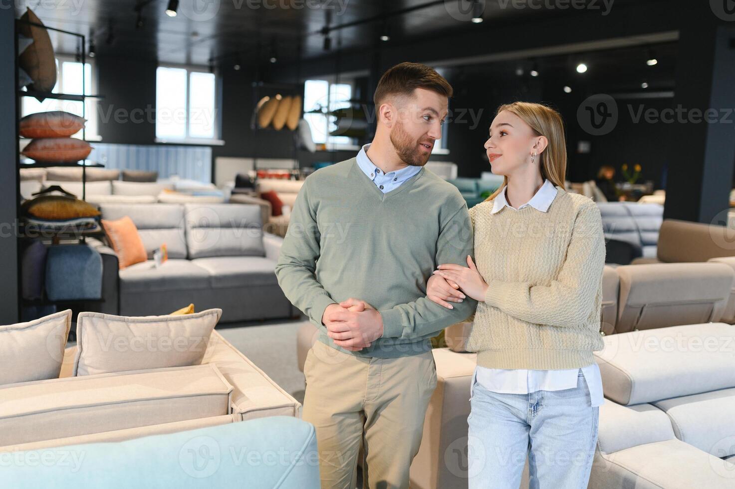 Couple choosing sofa and pillows at furniture store photo
