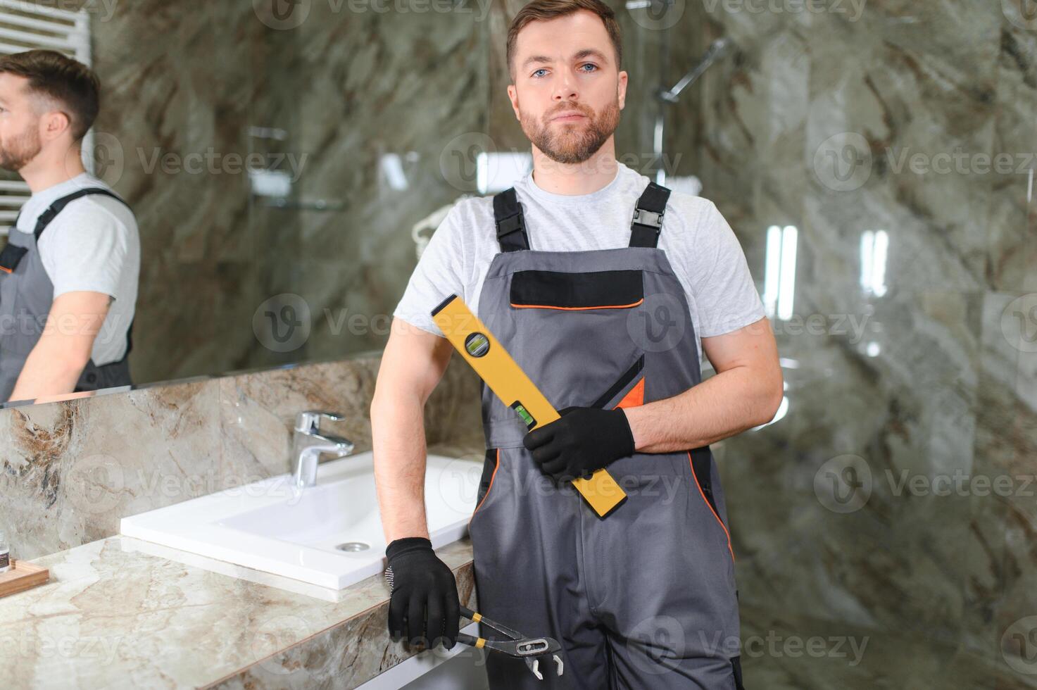 Plumber install sink in bathroom, checks even level of installation. Concept repair service plumbing photo