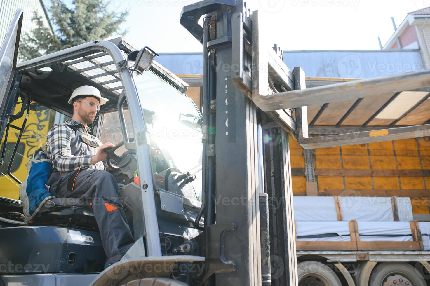 Portrait of professional forklift driver in factory's warehouse photo