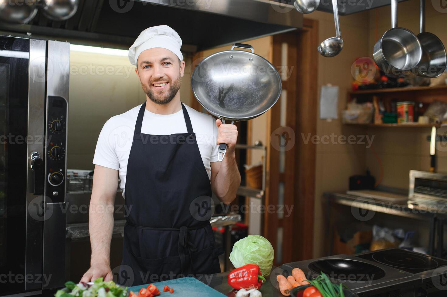 Chef cook in uniform cooking in the big cooker at the restaurant kitchen photo