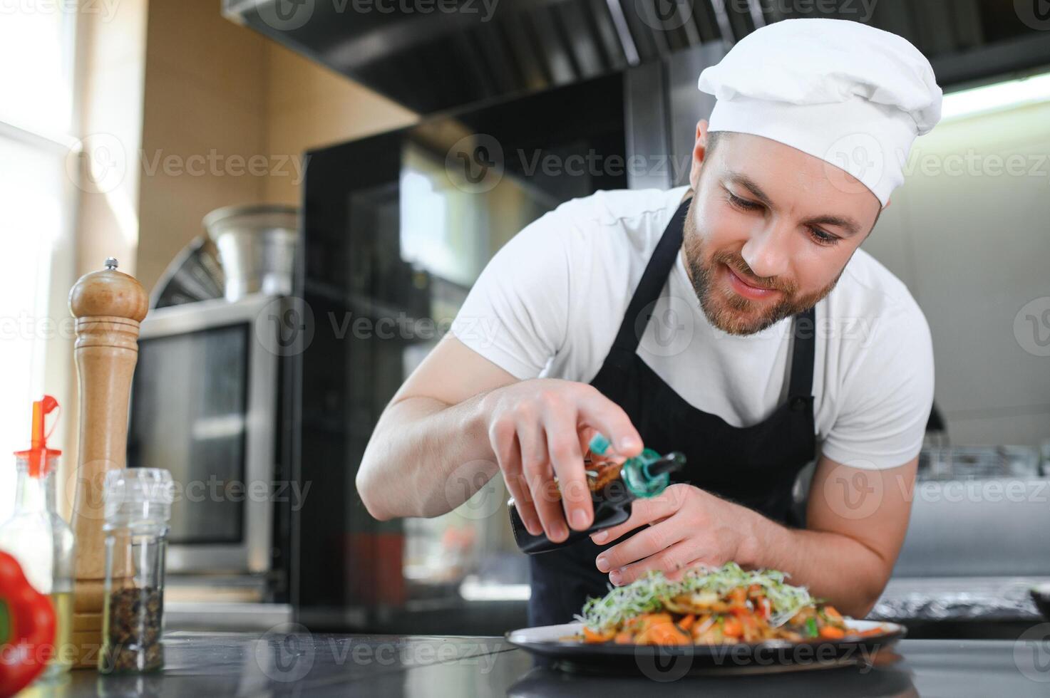 Chef cook in uniform cooking in the big cooker at the restaurant kitchen photo
