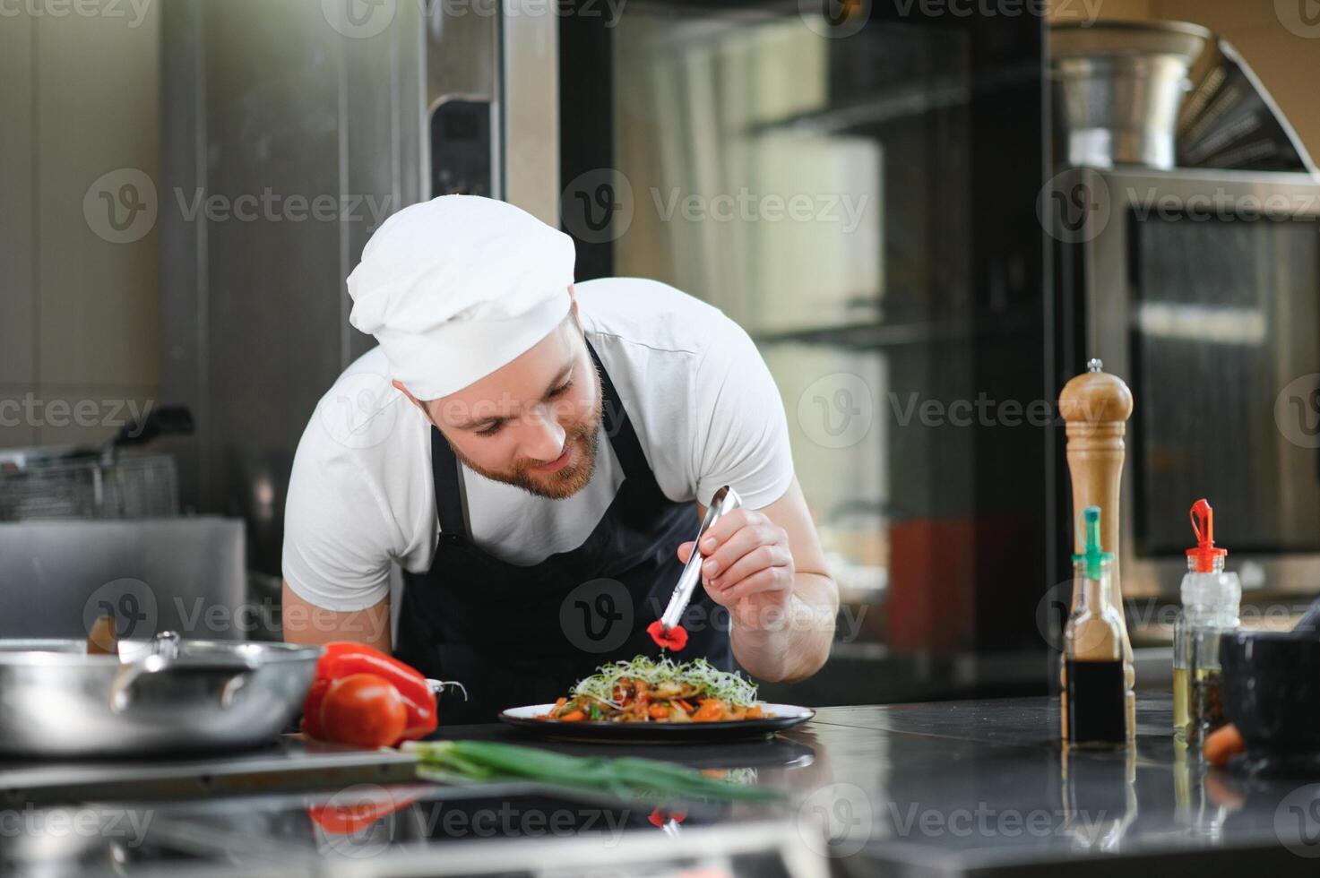 Chef cook in uniform cooking in the big cooker at the restaurant kitchen photo