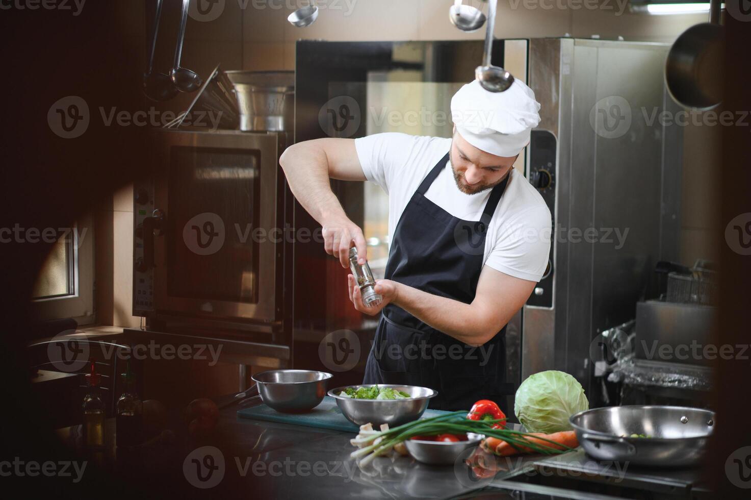 Chef cook in uniform cooking in the big cooker at the restaurant kitchen photo