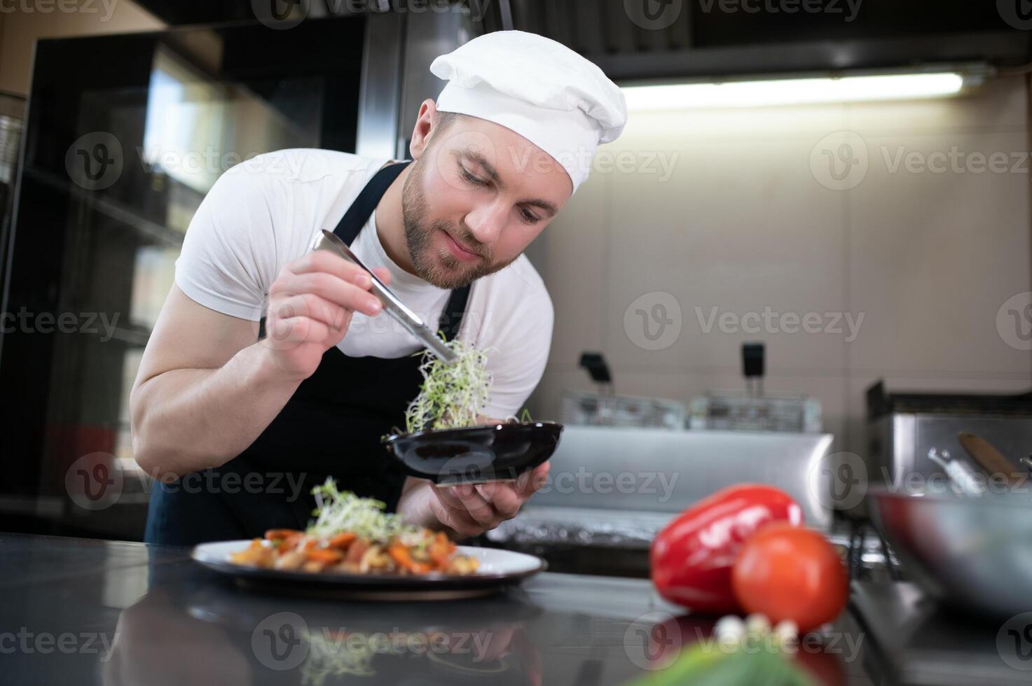 Chef cook in uniform cooking in the big cooker at the restaurant kitchen photo