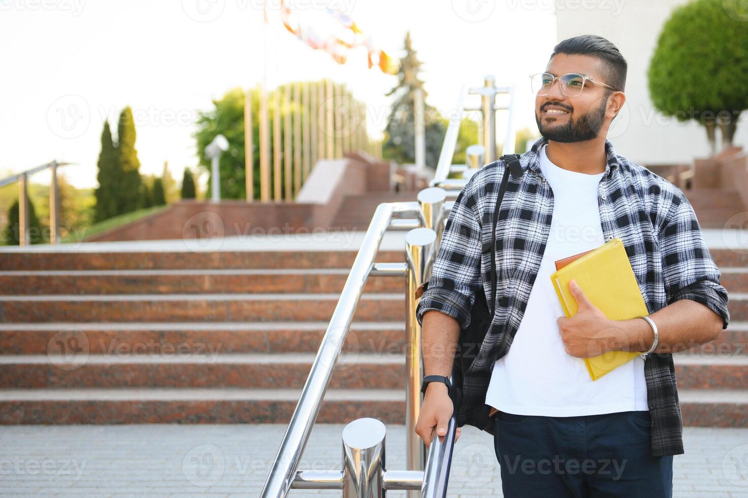 Handsome young Indian boy student with books and backpack. Education concept photo