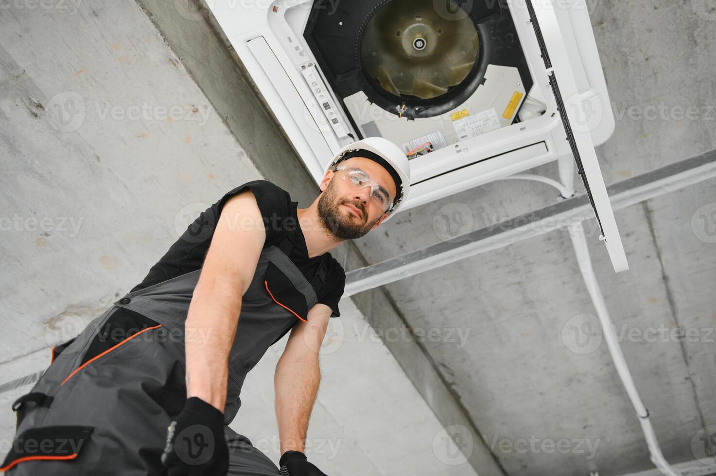 technician cleans air conditioner system in a modern apartment photo