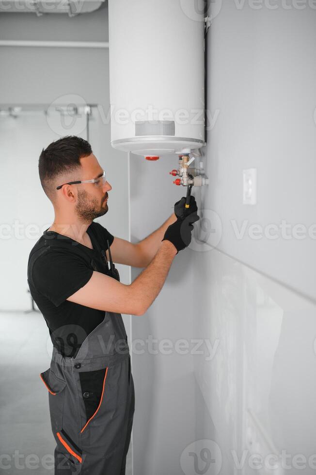 Professional plumber servicing a boiler photo