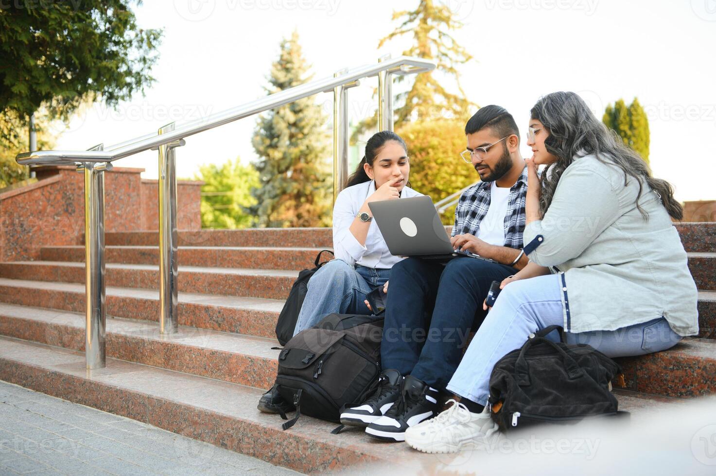 group of young students checking exam results or waiting for project approval on laptop at collage campus photo